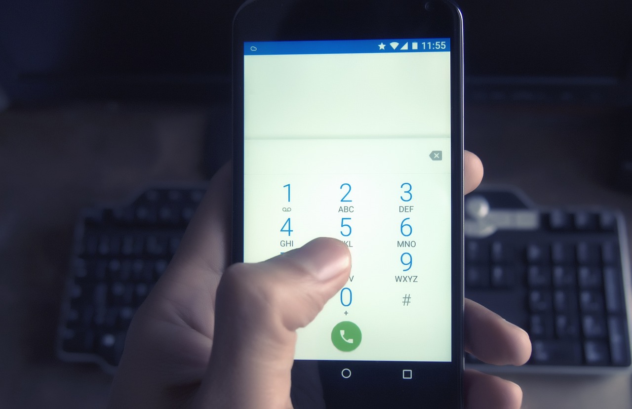 スマートフォンで電話をかける手元(会社からの連絡・直接電話のイメージ)